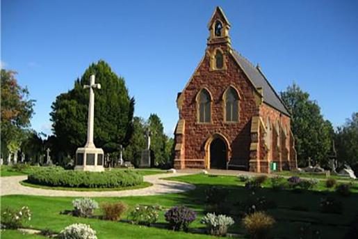 Chapel in Exeter Higher Cemetery with granite cross in foreground