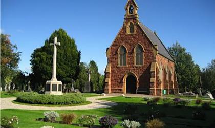 Chapel in Exeter Higher Cemetery with granite cross in foreground